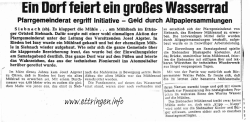 Ein Dorf feiert ein gro&szlig;es Wasserrad